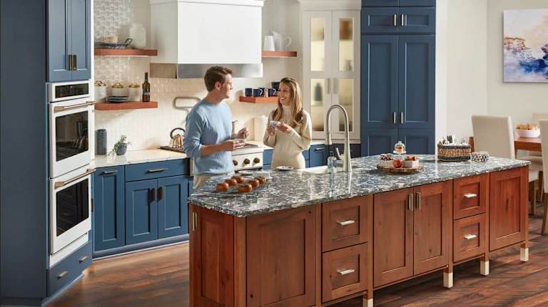 kitchen with wooden kitchen island and people eating and drinking coffee