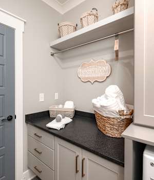 A Medium Density Fiberboard and Maple Laundry Room featuring Preston and Alto cabinet doors in Whisper and Ash from Wellborn Cabinet, Inc.