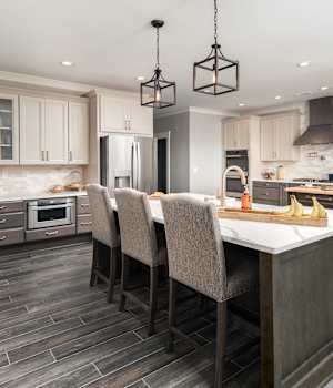 A Maple and Medium Density Fiberboard Kitchen and Active Living featuring Seville Square, Chelsea II, and Muriel cabinet doors in Castle Charcoal, Gray Mist Granite, and Ash from Wellborn Cabinet, Inc.