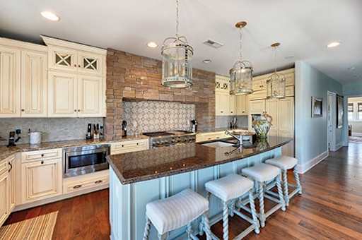 Light blue island cabinet in an off-white kitchen