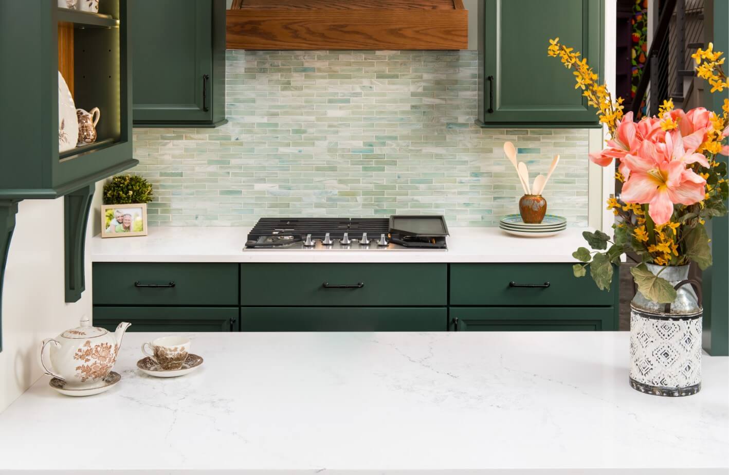 a dark green kitchen with white countertops